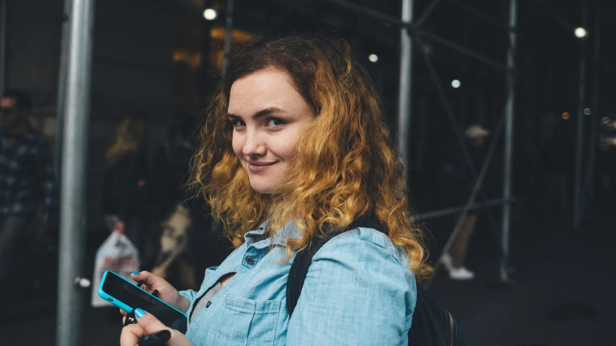 Corredora sonriendo mientras revisa sus fotos de carrera en el teléfono